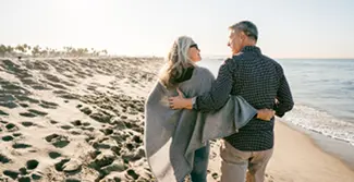 An elderly couple strolling at the beach